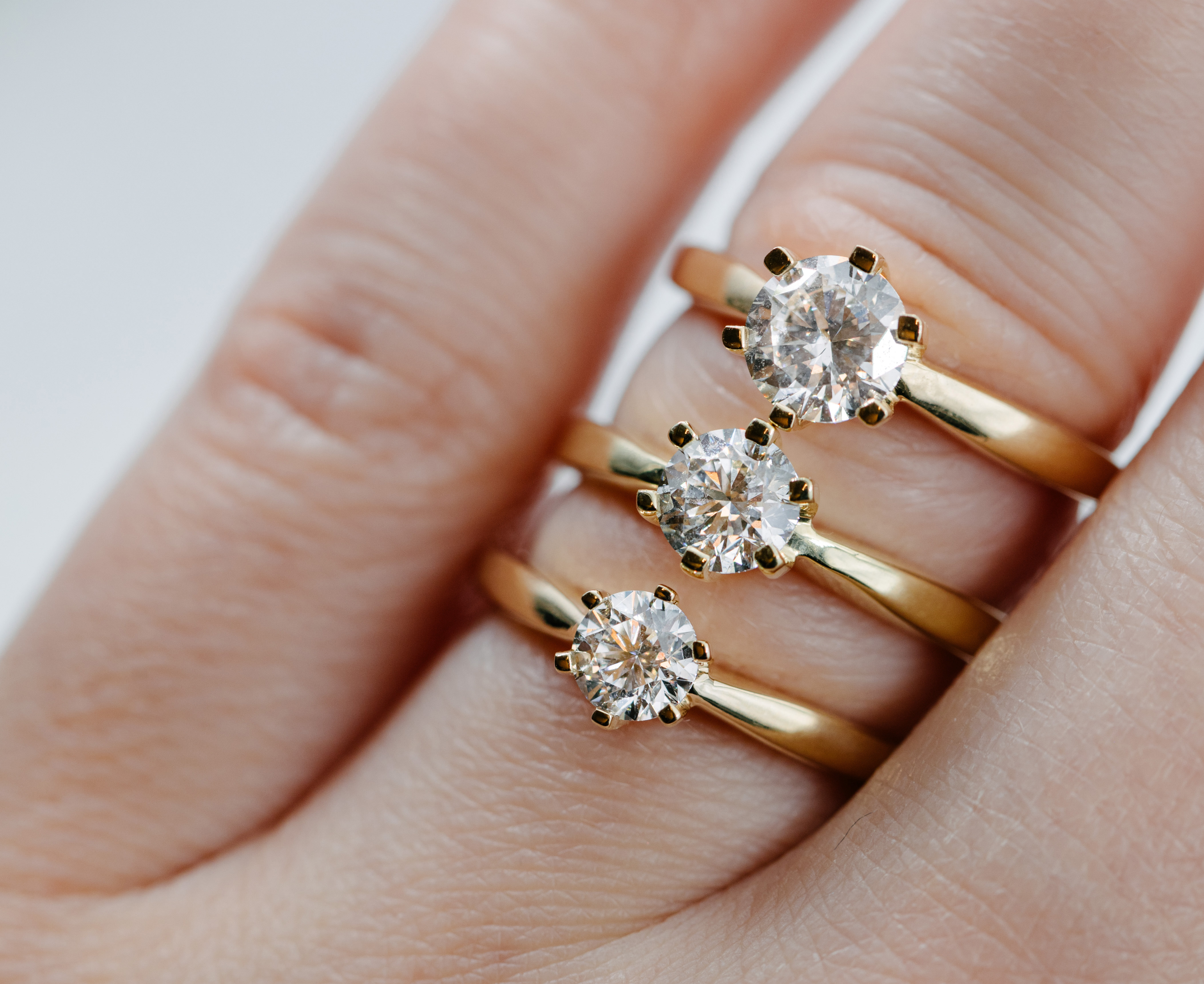Bilde av en hånd med en diamantring på en finger.
